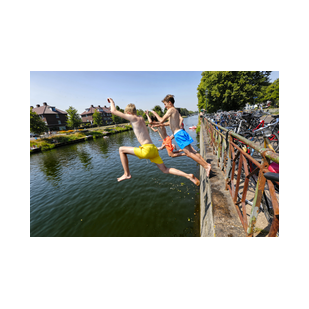 Jongens springen in het Merwedekanaal bij de sluis